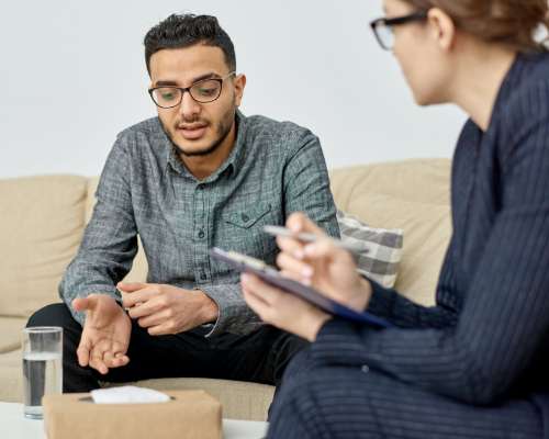 A man and woman discuss paperwork on a table