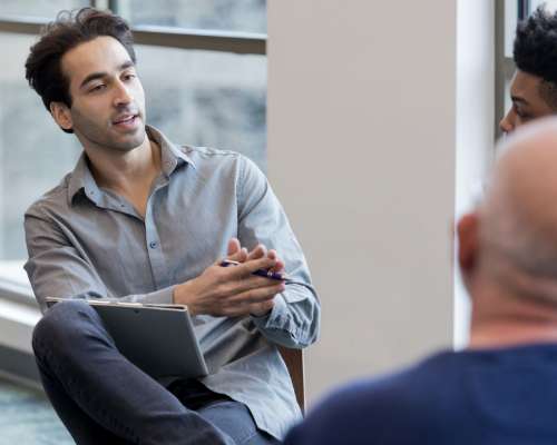 A mentor speaks to a group in a circle