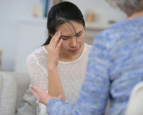 A woman touches her forehead in mild discomfort