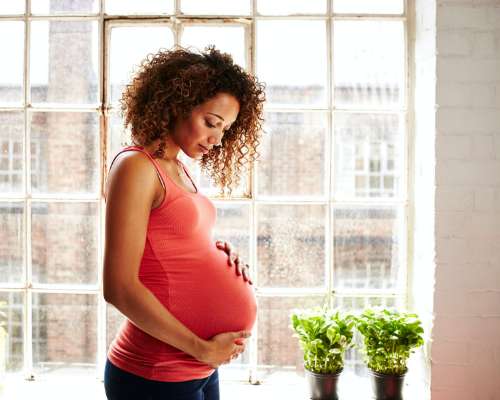 A pregnant woman hugs her belly