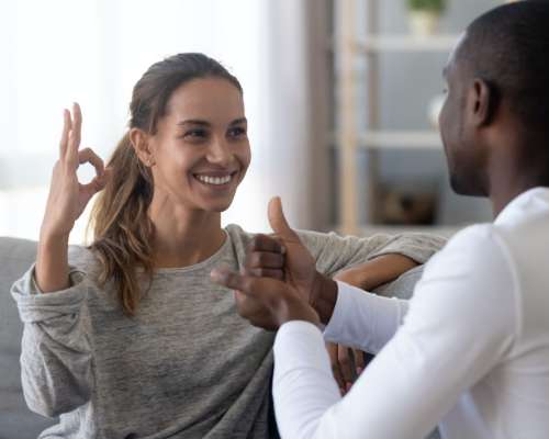 A woman using sign language speaks with a counselor